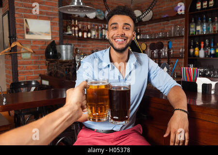 Hispanic Mann In Bar Clink Brille Toasten, trinken halten Bierkrüge, fröhliche Freunde treffen Stockfoto