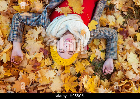Frau in aufgegebenen Mantel im Herbst Park liegen Stockfoto