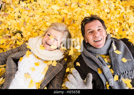 Aktive Senioren Paar im Herbst auf dem Boden liegenden park Stockfoto