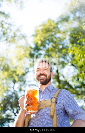 Mann in bayerischer Tracht hält Krug Bier Stockfoto