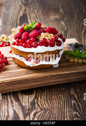 Selbst gemachter Butter Torte mit gepeitschter Creme Belag auf rustikalen Holztisch Stockfoto