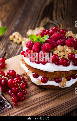 Selbst gemachter Butter Torte mit gepeitschter Creme Belag auf rustikalen Holztisch Stockfoto