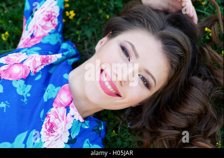 Schöne junge Frau draußen im grünen Rasen. Stockfoto