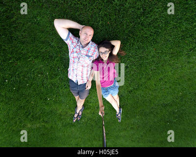 liebenden paar Mann und Frau liegt auf dem grünen Rasen Stockfoto