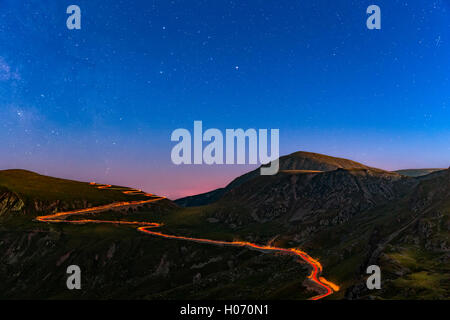 Transalpina Straße unter einem sternenklaren Nacht mit Traffic Routen entlang der kurvenreichen Straße Stockfoto