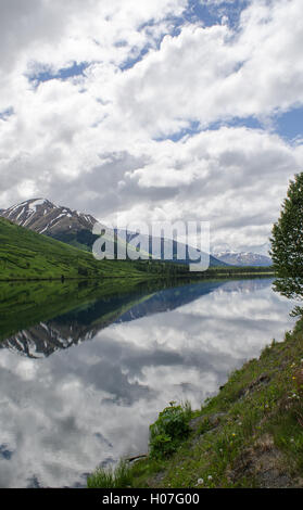 Ein sanfte, sonniger Tag in Alaska erstellt die perfekte Reflexionen in einem See am Straßenrand Stockfoto