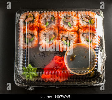 Sushi im Paket auf einem schwarzen Hintergrund Stockfoto