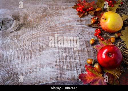 Grenze von Äpfeln, Beeren und Herbst Blätter auf dem rustikalen hölzernen Hintergrund. Thanksgiving-Hintergrund mit saisonalen Beeren und fru Stockfoto