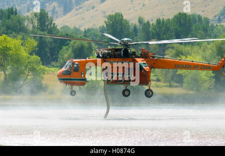 Hubschrauber findet am Wasser gegen Berg Wildfire, Wonderland Stockfoto