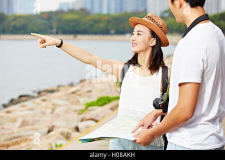 junge asiatische paar Touristen versuchen, eine Landschaft vor Ort mit Hilfe einer Karte lokalisieren Stockfoto