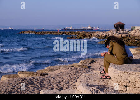 Junges israelisches Paar, das an der Promenade entlang bat Galim sitzt Ein Viertel an der Mittelmeerküste in der Hafenstadt Von Haifa im Norden Israels Stockfoto