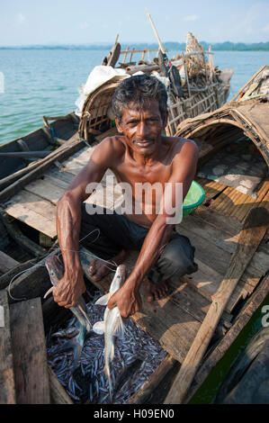 Ein Fischer hält einen frischen Fang auf Kaptai See in den Chittagong Hill Tracts, Bangladesch, Asien Stockfoto