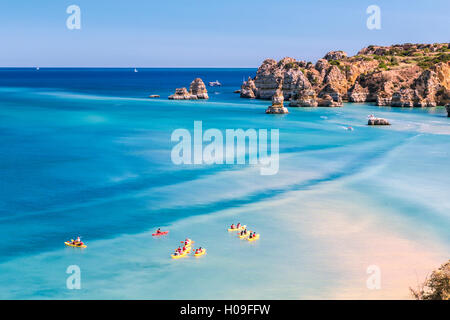 Kanus im türkisfarbenen Wasser des Atlantischen Ozeans rund um Praia Dona Ana Strand, Lagos, Algarve, Portugal, Europa Stockfoto