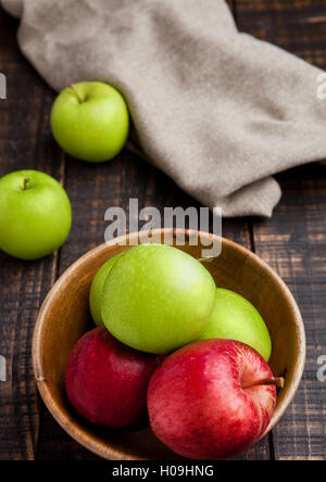 Grüne und rote Bio-Äpfel in Schüssel auf Holzbrett. Gesunde Ernährung Stockfoto