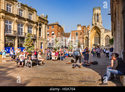 Menschenmassen beobachten, ein Mann Band Straßenmusik in St Helen's Square, York, North Yorkshire, England, UK Stockfoto