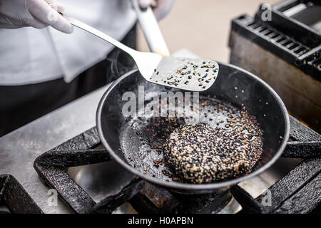 Roter Thunfisch-Steak mit weißen und schwarzen Sesam Kruste in Öl gebraten Stockfoto