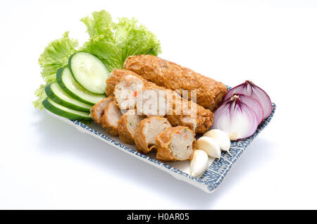 Einfügen von Ngor Hiang oder Fisch mit Knoblauch, Zwiebeln, Gurken und Salat auf Teller Stockfoto