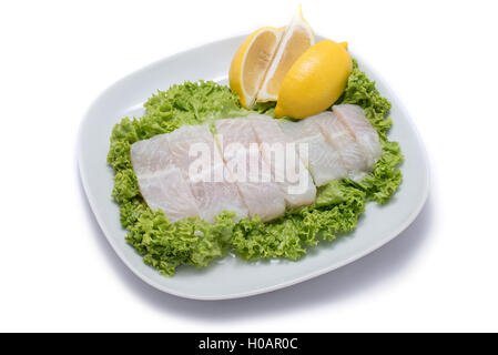 Scheiben von Dory Fisch mit Salat und Zitrone auf weißen Teller Stockfoto