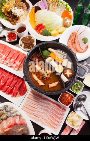 Eine spezielle Hot Pot im chinesischen Stil mit Rindfleisch, Schweinefleisch, Meeresfrüchte, Pilze, Gemüse, Garnelen und Kräutern Stockfoto