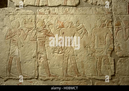 Ägyptische Kunst. Polychrome Relief Darstellung einer religiösen Prozession mit Nahrungsmitteln an den Verstorbenen. Mastaba des Iynefert. Altes Königreich. 5. Dynastie. Nekropole von Sakkara. Stockfoto