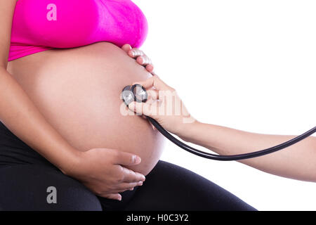 Nahaufnahme der Bauch einer schwangeren Frau, die mit einem Stethoskop untersucht Stockfoto