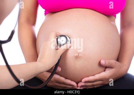 Nahaufnahme der Bauch einer schwangeren Frau, die mit einem Stethoskop untersucht Stockfoto