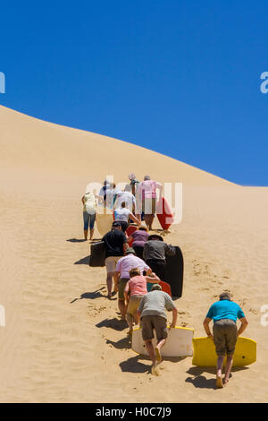 Menschen, die eine hohe Sanddüne in Neuseeland Klettern Stockfoto