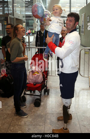 Der Brite David Henson 19 Monate alte Tochter Emily neben Frau Hayley (links) halten, wie er wieder am Flughafen Heathrow, London ankommt. PRESSEVERBAND Foto. Bild Datum: Dienstag, 20. September 2016. Die Paralympics GB Squad kommen zurück in das Vereinigte Königreich nach dem sammeln 147 Medaillen, zweite in 2016 Rio Paralympics Medaillenspiegel, übertrifft ihre insgesamt 120 von London 2012 zu beenden. PRESSEVERBAND Foto. Bildnachweis sollte lauten: Steve Parsons/PA Wire Stockfoto