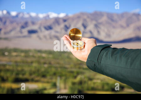 Junge Reisende auf der Suche bei Compass im Himalaya Bergblick Hintergrund (Schwerpunkt Kompass) Stockfoto