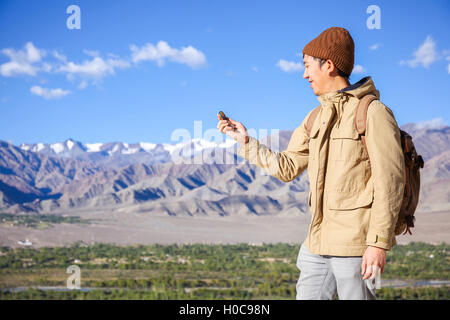 Asiatische junge Reisende auf der Suche bei Compass im Himalaya Bergblick Hintergrund in Leh, Ladakh, Indien Stockfoto