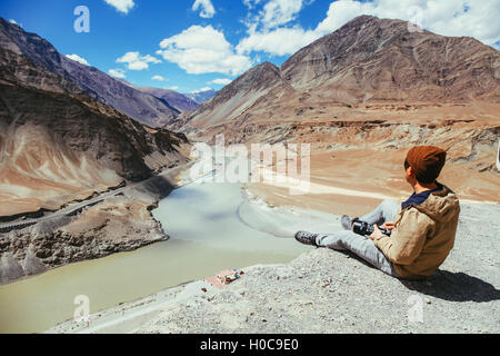 Glücklich Jüngling sitzt auf der Klippe auf der Reise in Indus Fluß in Leh, Ladakh, Indien Stockfoto