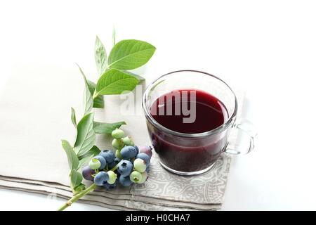 Heidelbeersaft mit rohem Obst und Tee Tasse auf weißem Hintergrund Stockfoto