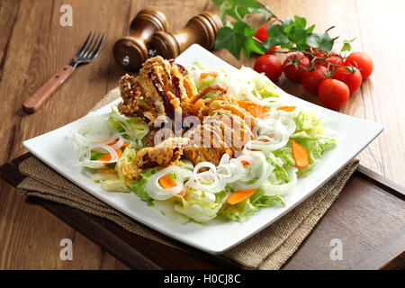 Ein neues Konzept des Essens Salate knackig und würzig gebratener Tintenfisch mit Salat Tong Stockfoto