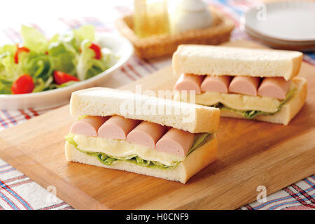 Asiatische Hamburger Wurst, Käse und Salat auf Holzbrett Stockfoto