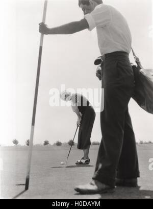 Golfspielerin und ihr caddy Stockfoto