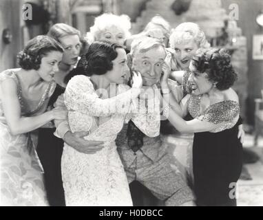 Älterer Mann, umgeben von Flirtatous junge Frauen Stockfoto