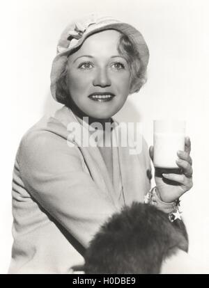 Frau mit Hut mit einem Glas Milch Stockfoto
