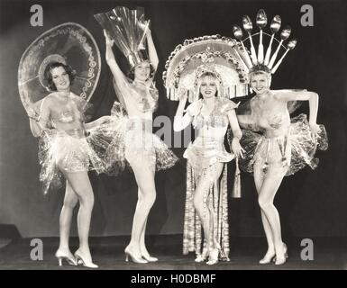 Vier Frauen tragen lustige Hüte und Kostüme Stockfoto