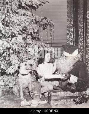Santa Claus Geschenk für kleine Mädchen und ihr Hund Stockfoto