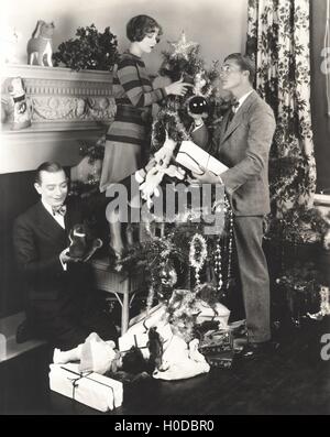 Männer helfen Frau Weihnachtsbaum zu Hause dekorieren Stockfoto