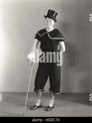 Mann posiert in Manschetten, Zylinderhut und Zirkus-Kostüme Stockfoto
