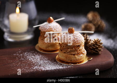 Praline Haselnuss Choux auf Holztablett mit Kiefer für Weihnachten Stockfoto