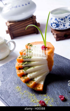 Milch-Papaya-Kuchen auf Felsplatte mit Teekanne im restaurant Stockfoto
