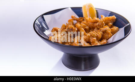 Fried Ring Octopus mit Zitrone im blauen chinesischen Schale auf weißem Hintergrund Stockfoto