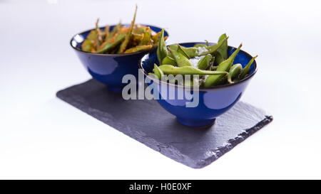 Edamame japanische gedämpft soyal Bohnen in blaue chinesische Schüssel auf weißem Hintergrund Stockfoto