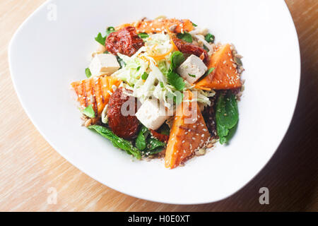 Salat mit Kürbis und Kichererbsen auf weißen Teller Stockfoto
