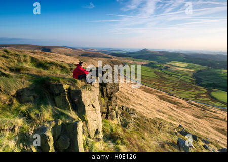 Eine Walker saß auf leuchtende Tor mit Blick auf Shutlinsloe, Peak District National Park, Cheshire. Stockfoto