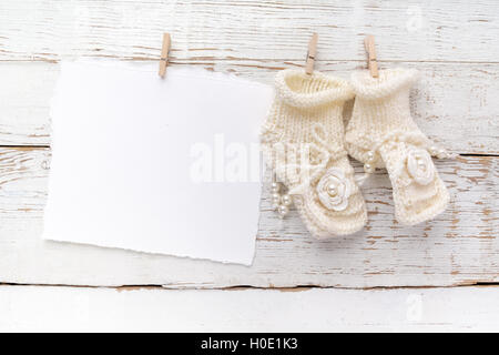 Neue Born oder Taufe Greeting Card leer mit Baby Mädchen Schuhe auf weißem Holz Hintergrund Stockfoto