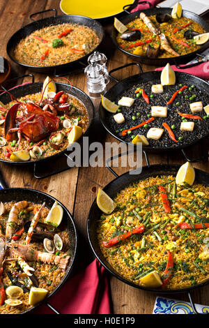 Schwarzen Pfannen von gebratenem Hummer, Gottesanbeterin Garnelen, Shrimps, Muscheln und Krabben mit Zitrone, Chili und Kräutern auf Holztisch in arabischen Stockfoto