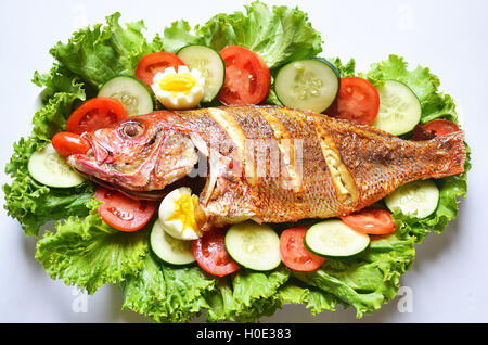 Gebratenen Fischsalat mit Tomaten, Gurken und Salat auf weißem Hintergrund Stockfoto